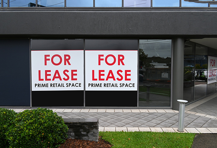 Commercial retail space with large For Lease signs in windows